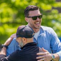 The winning teammates smile and hug after their victory